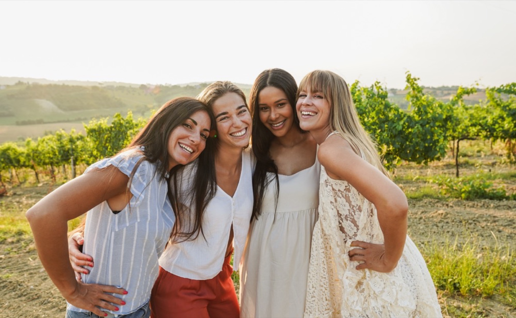 Friends smiling together outdoors at sunset